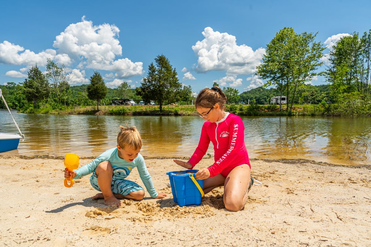 Kids building sandcastles on a lake beach