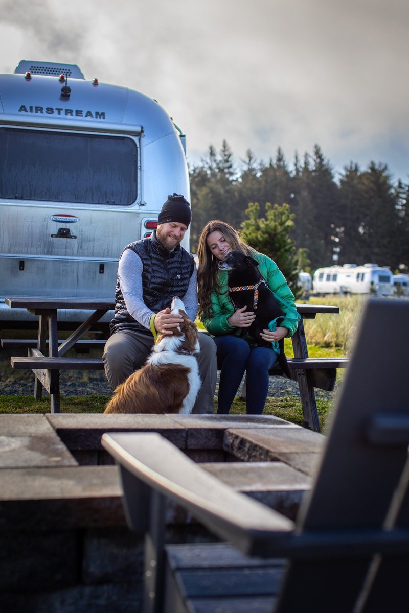 Couple with an Airstream trailer at a waterfront campground