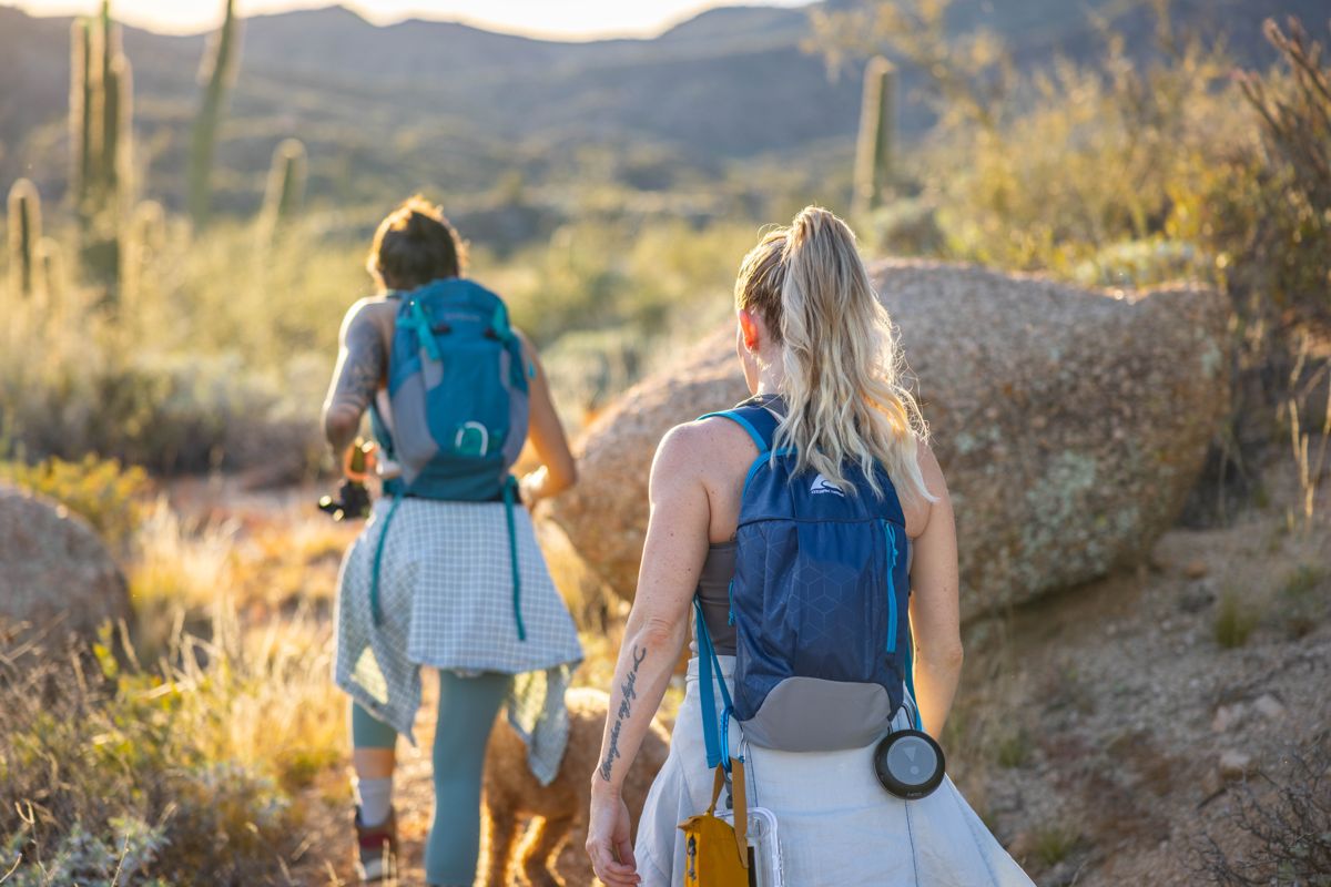 Couple hiking past desert boulders