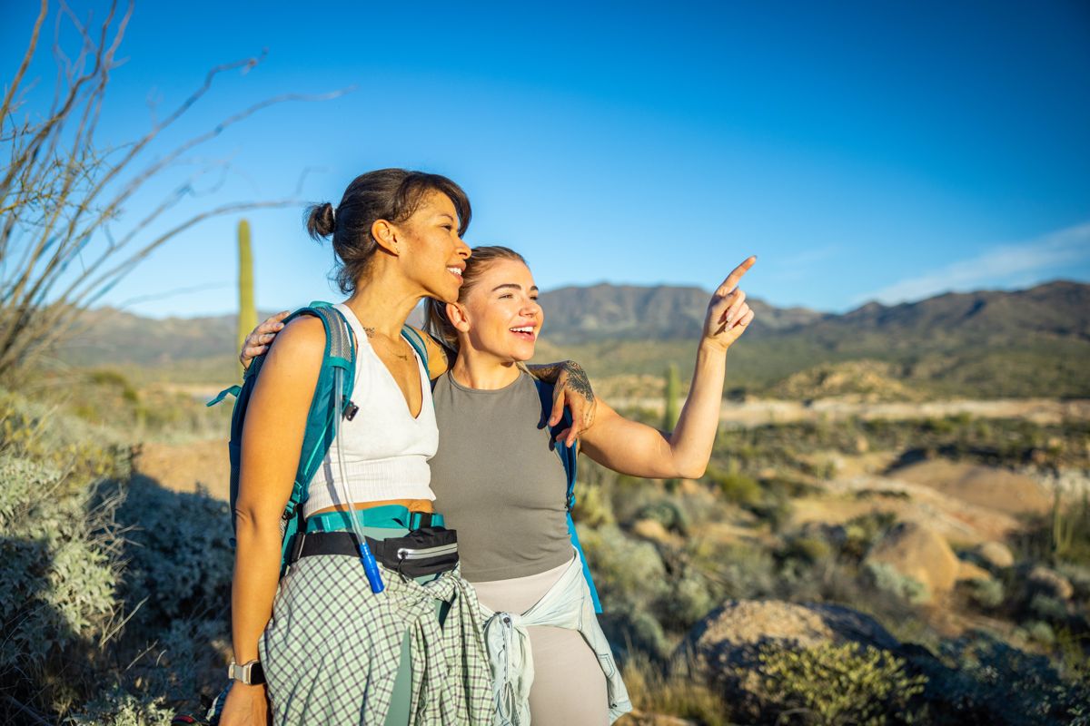 Friends pointing out the view on a desert hike