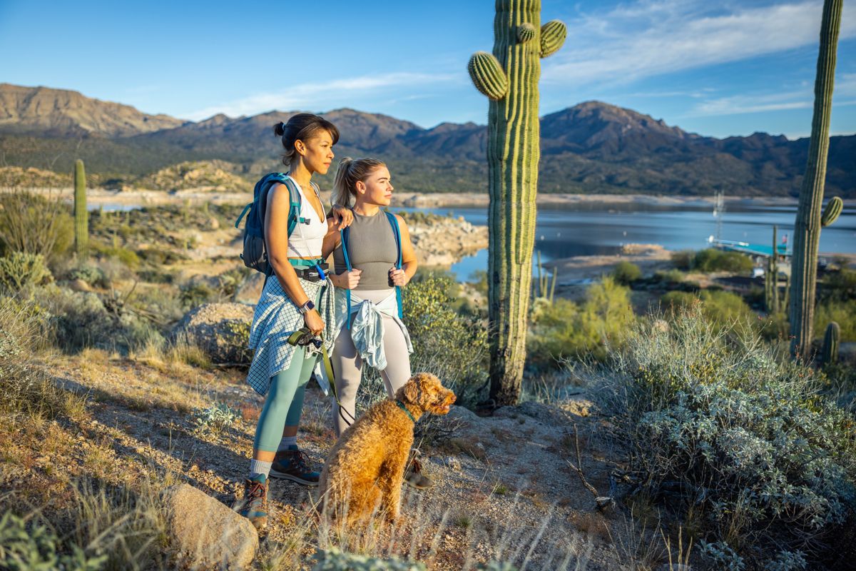 Friends with their dog on a lakeside desert trail