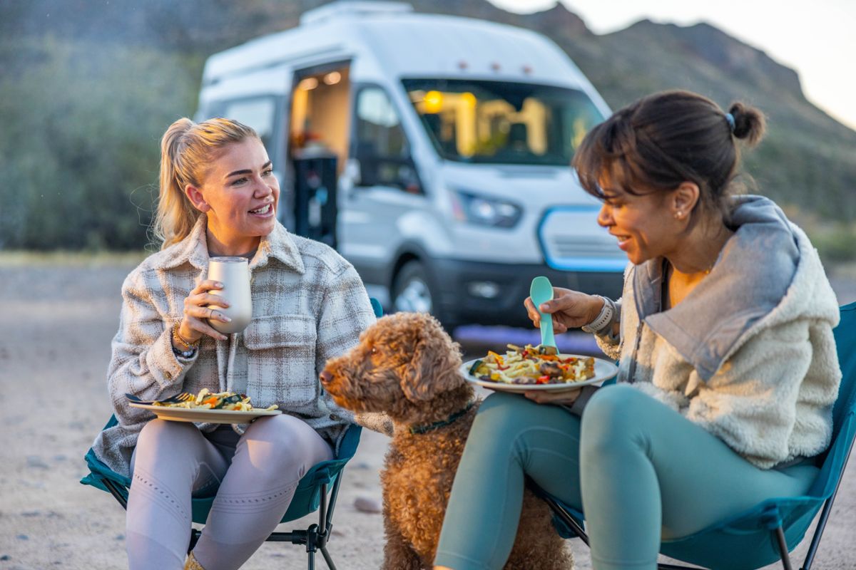Friends and their dog relaxing at a desert camp
