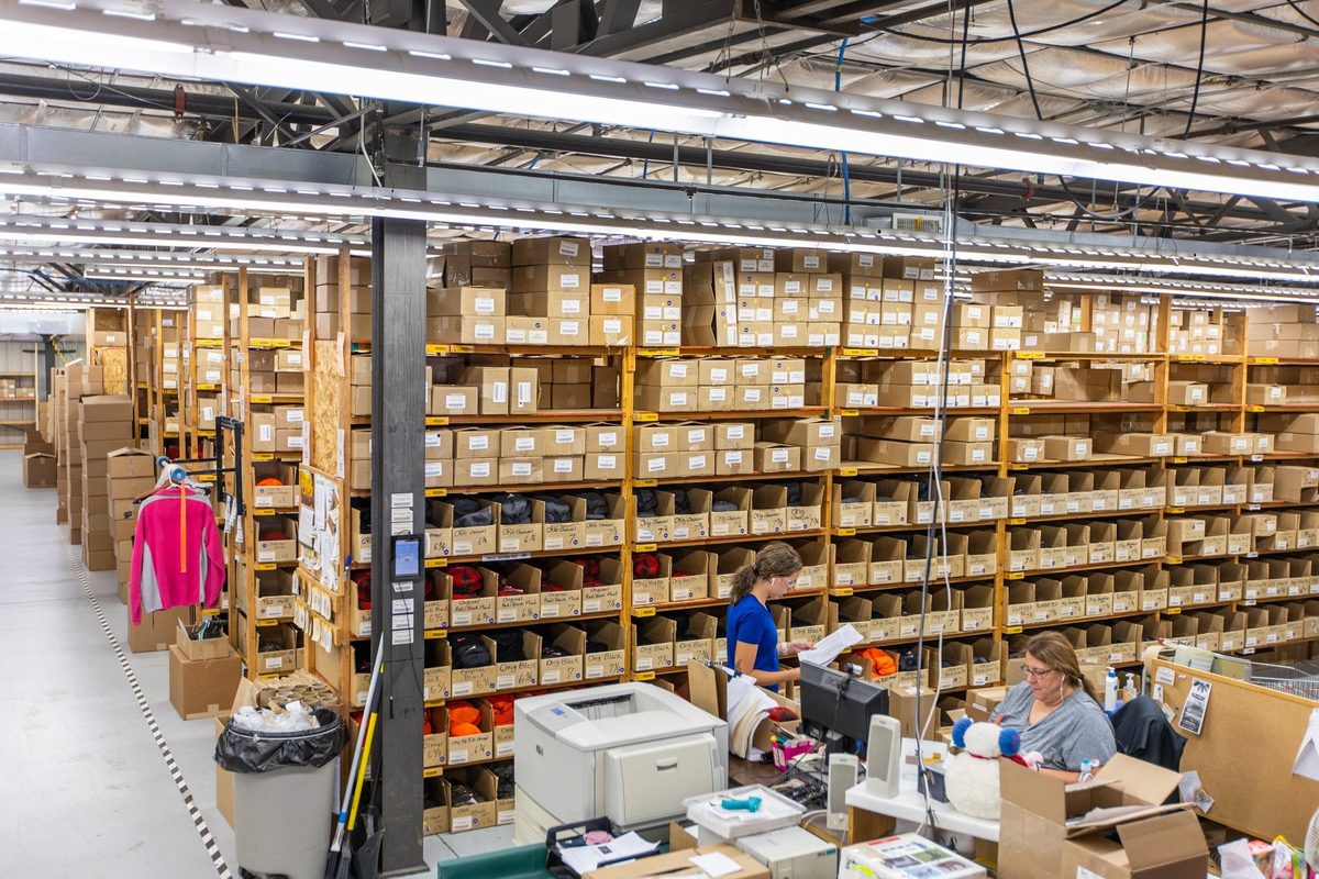 Workers sewing and finishing outdoor apparel on a factory floor