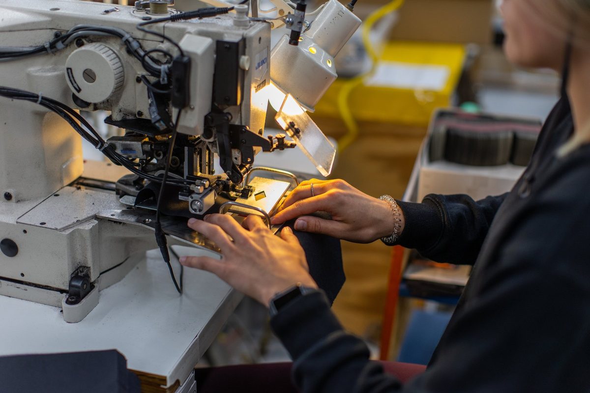 Workers sewing and finishing outdoor apparel on a factory floor