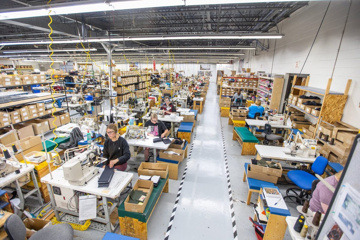 Workers sewing and finishing outdoor apparel on a factory floor