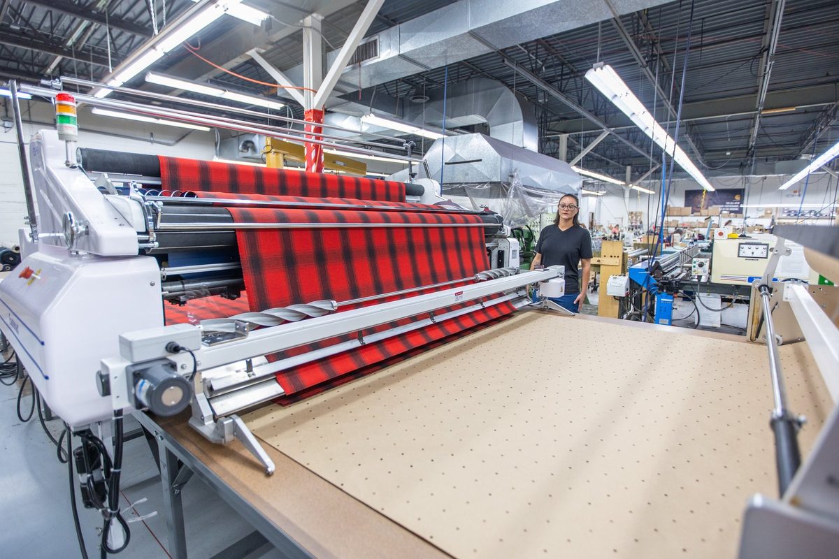 Workers sewing and finishing outdoor apparel on a factory floor