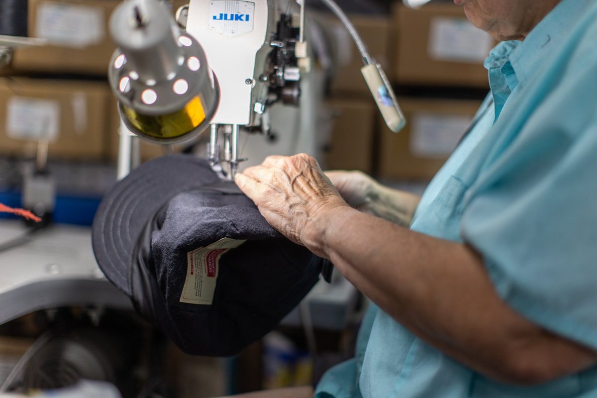 Workers sewing and finishing outdoor apparel on a factory floor
