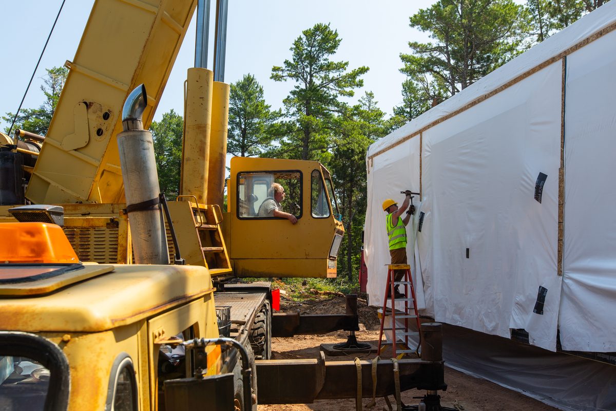 Crane setting a modular home section on build day