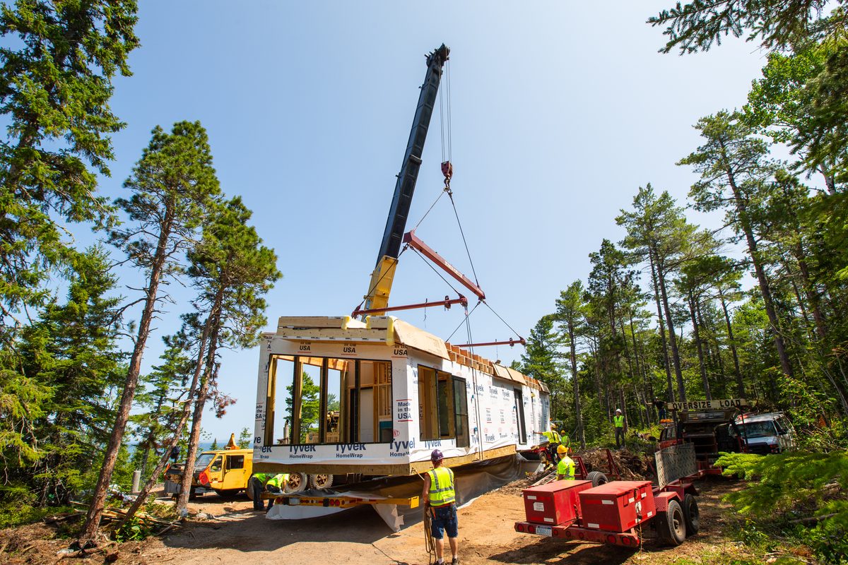 Crane setting a modular home section on build day