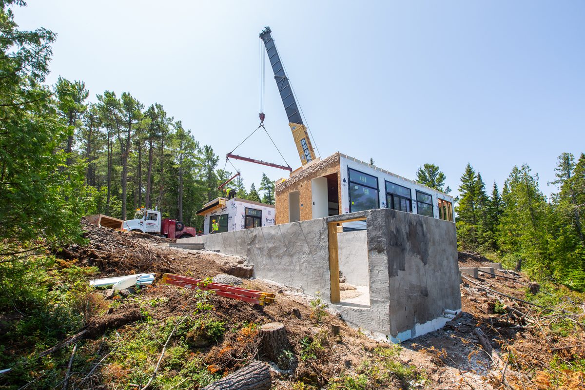Crane setting a modular home section on build day