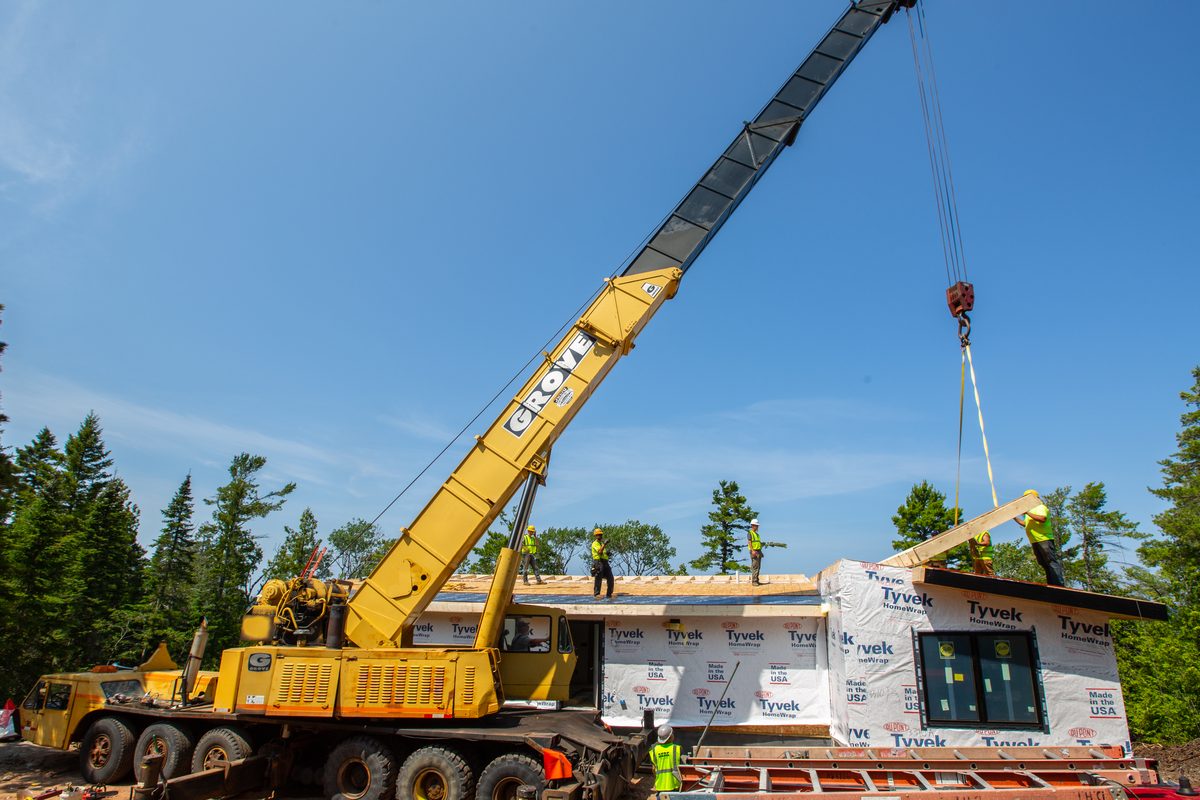 Crane setting a modular home section on build day