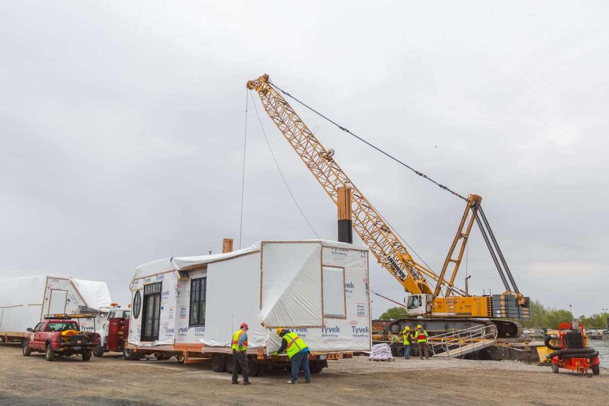 Crane setting a modular home section on build day
