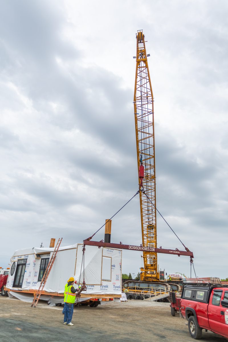 Crane setting a modular home section on build day