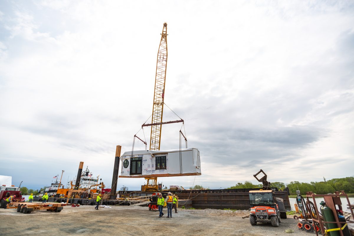 Crane setting a modular home section on build day