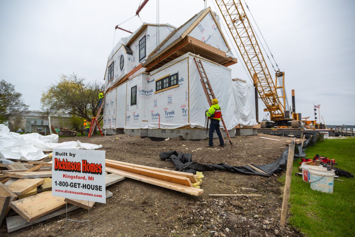 Crane setting a modular home section on build day