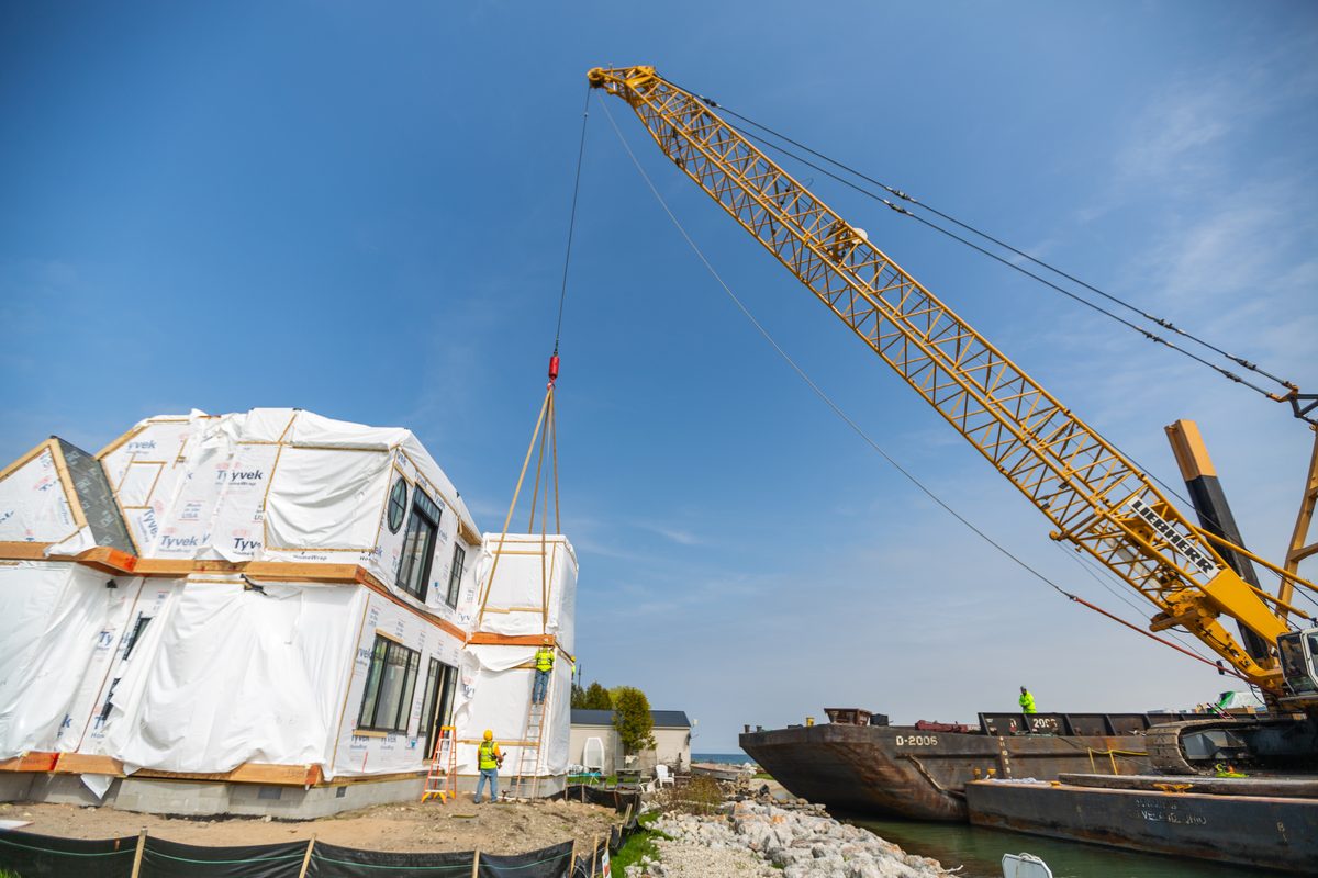 Crane setting a modular home section on build day