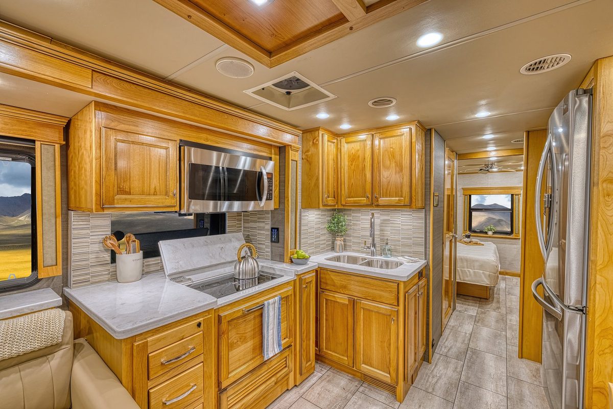 Luxury motorhome interior with kitchen, living area and cabin details