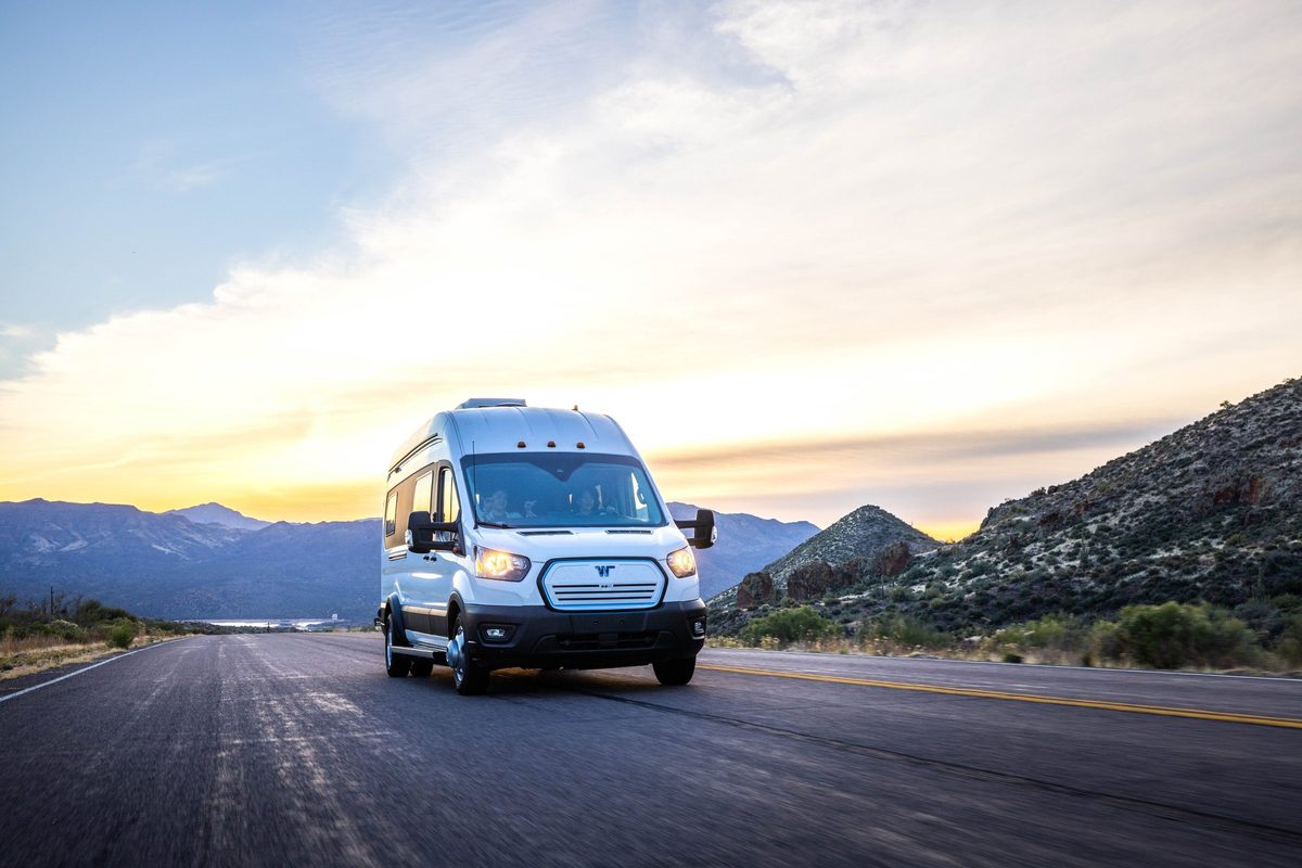 Couple traveling in a camper van on a mountain road trip
